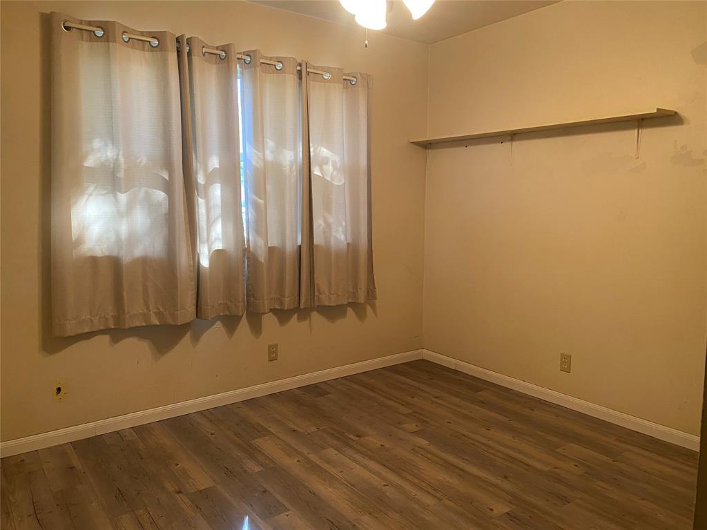 808 North Hughes Street Howe, TX 75459 - Photo 12 of 19 a view of a room with wooden floor and a window