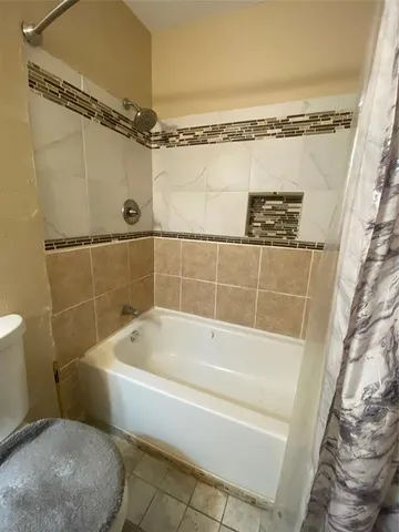 a white bath tub sitting next to a toilet