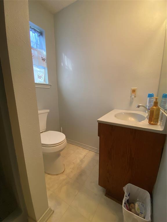 808 North Hughes Street Howe, TX 75459 - Photo 17 of 19 a bathroom with a sink toilet and vanity