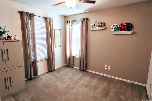 a view of an empty room with a window and refrigerator