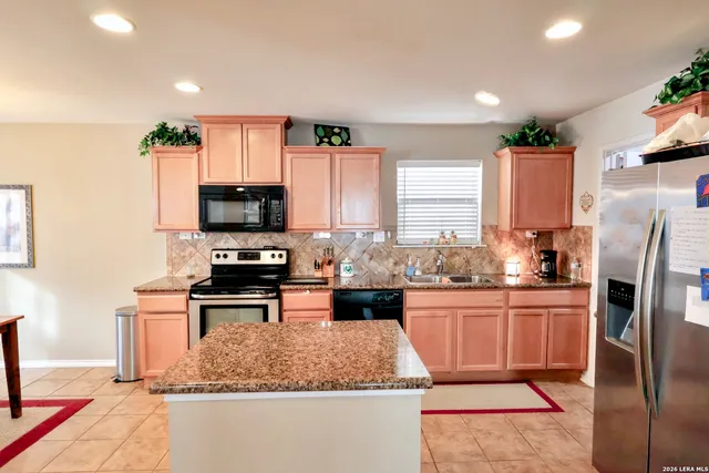 a kitchen with stainless steel appliances granite countertop a stove refrigerator sink and microwave