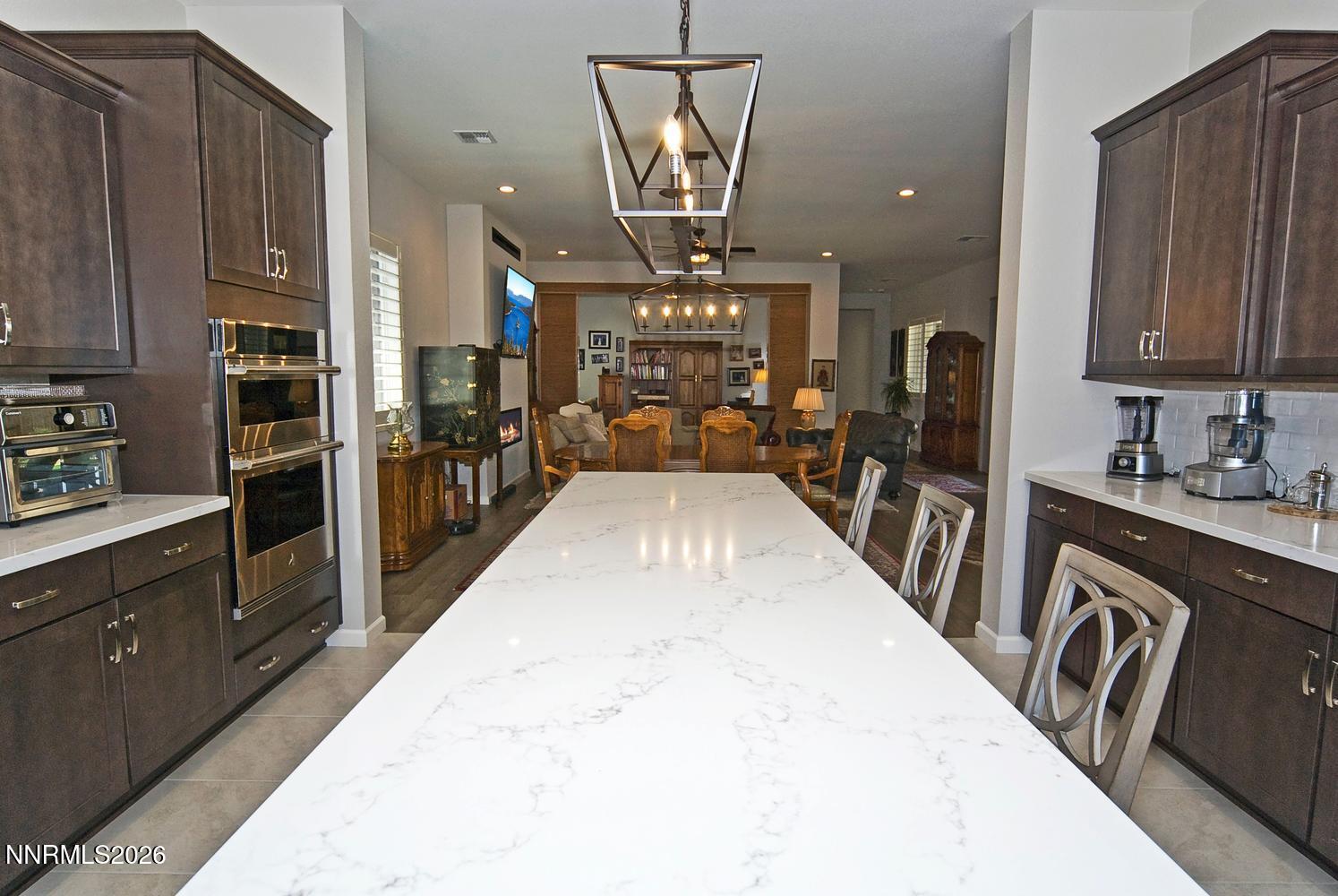2332 Hammer Falls Drive Reno, NV 89521 - Photo 21 of 57 a very nice looking kitchen with granite countertop a stove a sink a refrigerator and blue cabinets with wooden floor