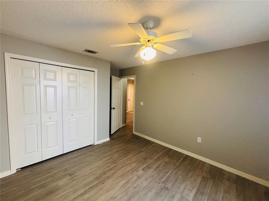 177 North Golf Harbor Path Inverness, FL 34450 - Photo 18 of 27 an empty room with wooden floor fan and windows