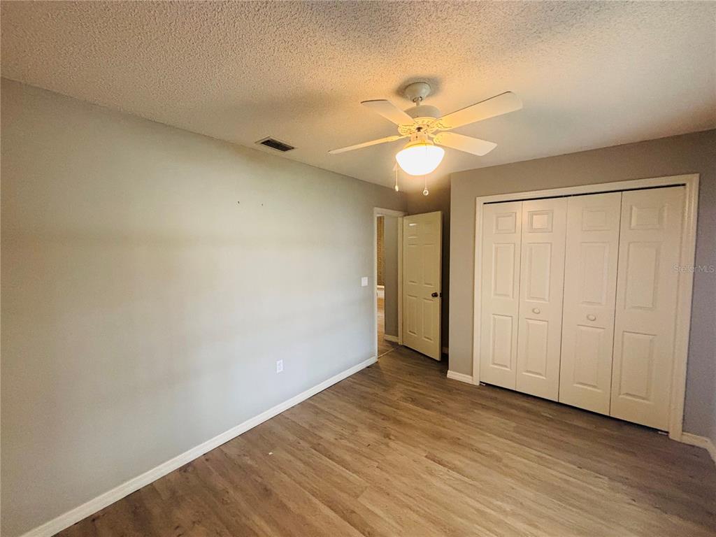 177 North Golf Harbor Path Inverness, FL 34450 - Photo 19 of 27 an empty room with wooden floor fan and windows