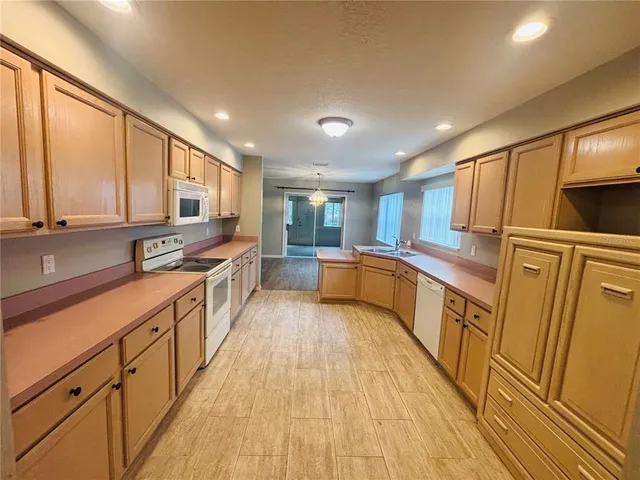 a large kitchen with stainless steel appliances sink a microwave and cabinets