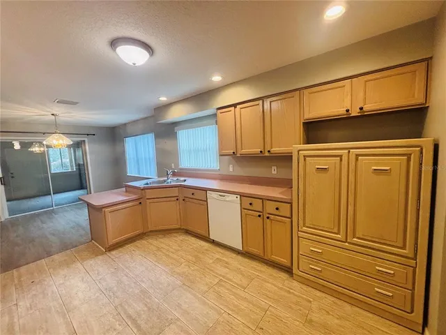 a large kitchen with stainless steel appliances wooden cabinets and a stove
