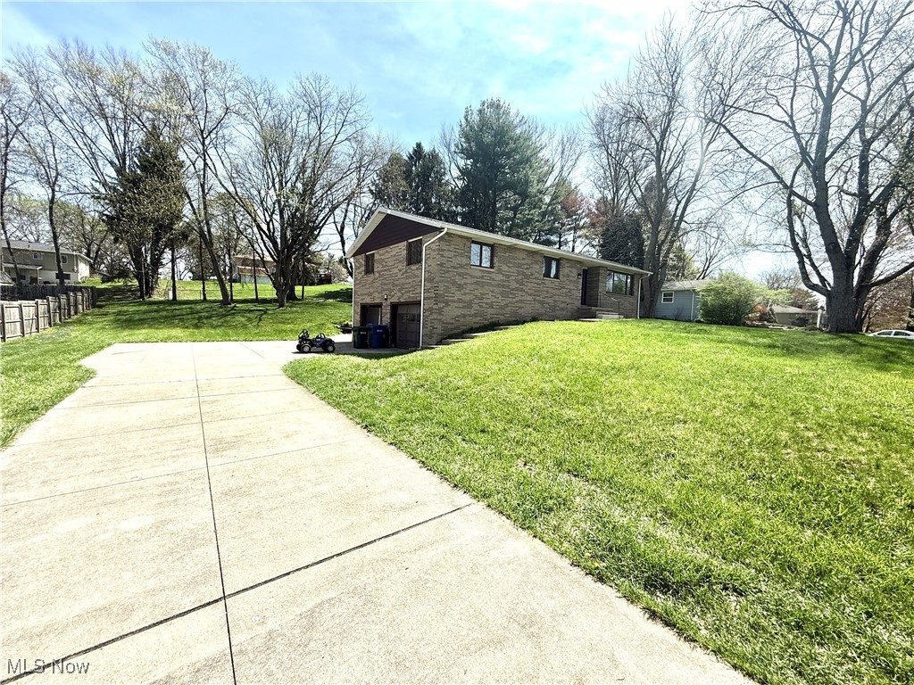 4669 Mars Road Uniontown, OH 44685 - Photo 1 of 31 View of home's exterior with a yard, concrete driveway, stone siding, and a garage