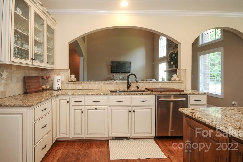 159 Abbington Place, Unit 16 Locust, NC 28097 - Photo 15 of 47 a kitchen with granite countertop a sink cabinets and wooden floor