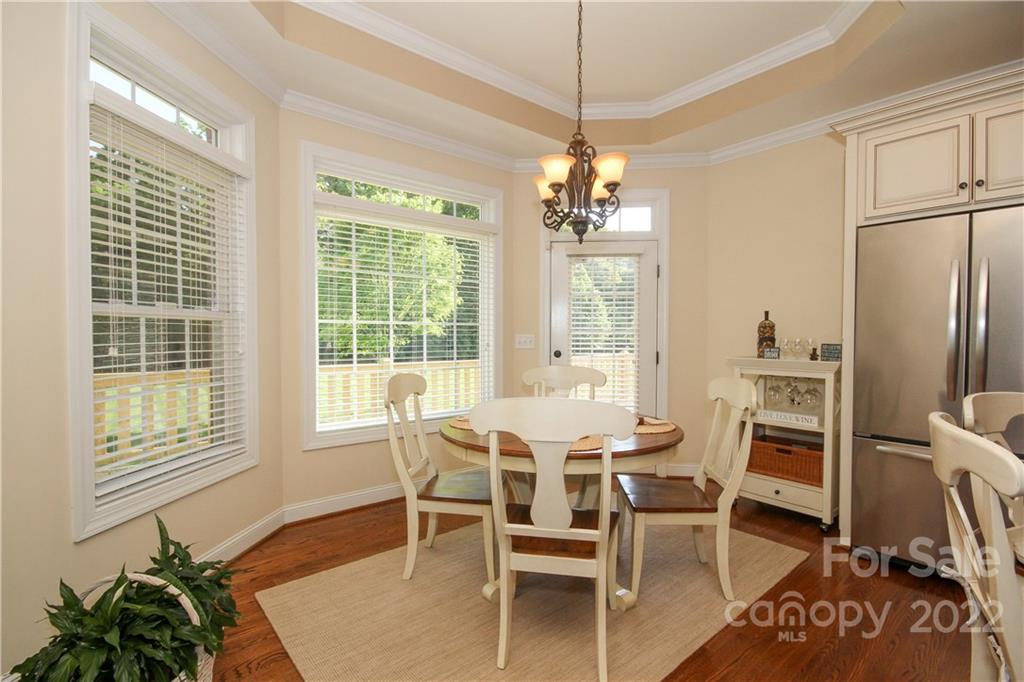 159 Abbington Place, Unit 16 Locust, NC 28097 - Photo 18 of 47 a dining room with furniture a chandelier and wooden floor