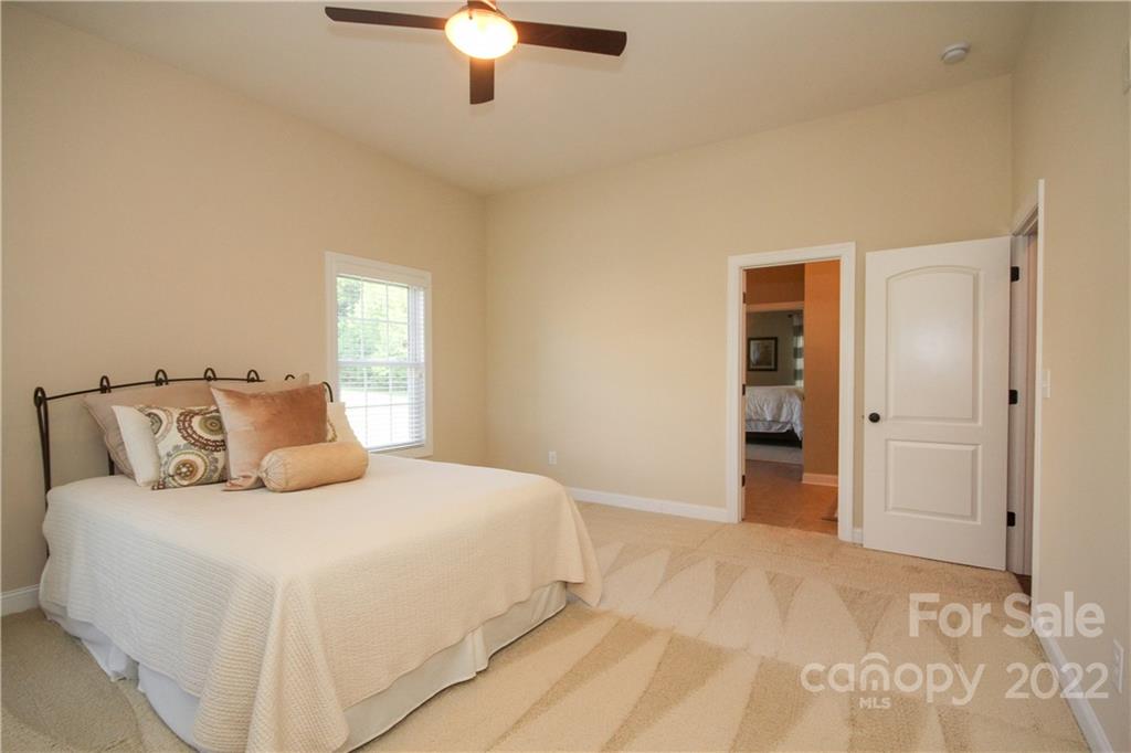 159 Abbington Place, Unit 16 Locust, NC 28097 - Photo 23 of 47 a bedroom with a large bed and a chandelier