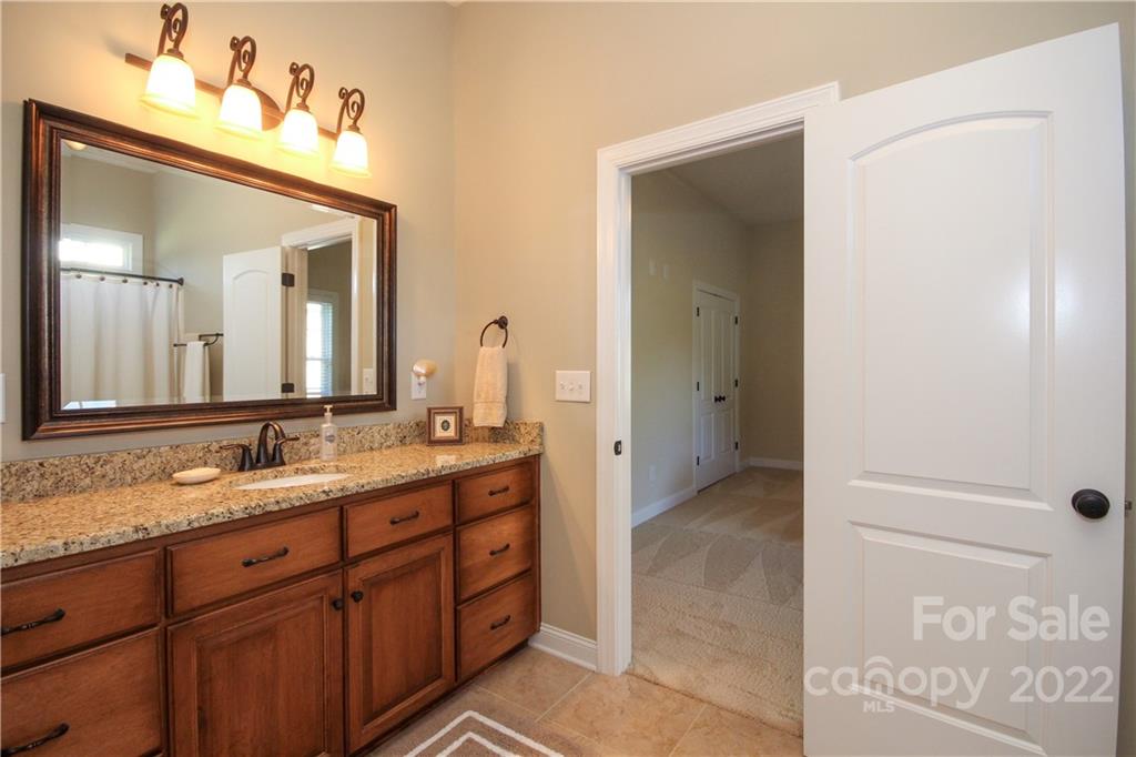 159 Abbington Place, Unit 16 Locust, NC 28097 - Photo 24 of 47 a bathroom with a granite countertop sink and a mirror