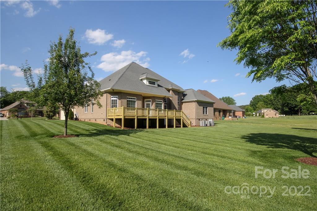 159 Abbington Place, Unit 16 Locust, NC 28097 - Photo 41 of 47 a view of a big house with a big yard and large trees