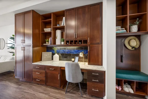 a view of kitchen island with stainless steel appliances wooden cabinets and chair