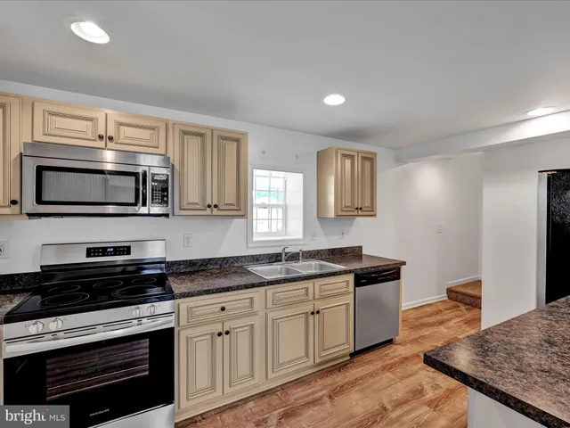 a kitchen with stainless steel appliances granite countertop a stove a sink and a microwave