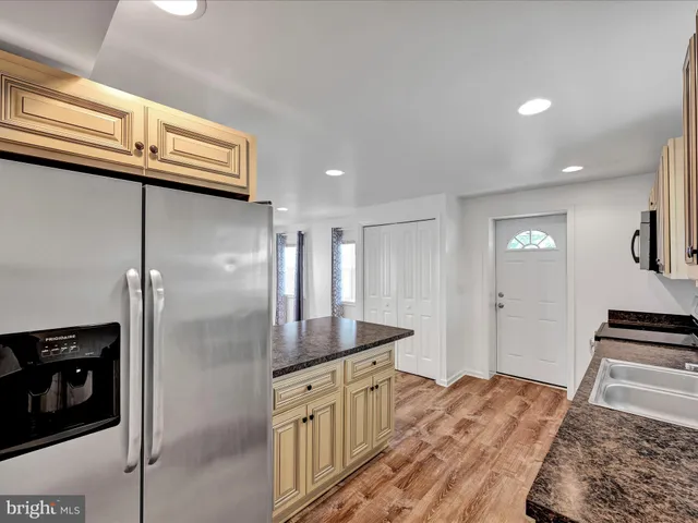 a kitchen with a refrigerator and a stove top oven