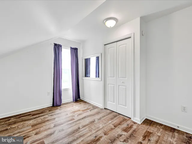 an empty room with wooden floor and closet