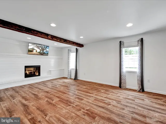 a view of an empty room with a fireplace and a window
