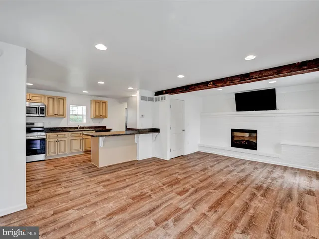 a large kitchen with kitchen island a sink stainless steel appliances and cabinets