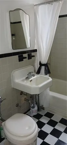 a bathroom with a sink and mirror with toilet