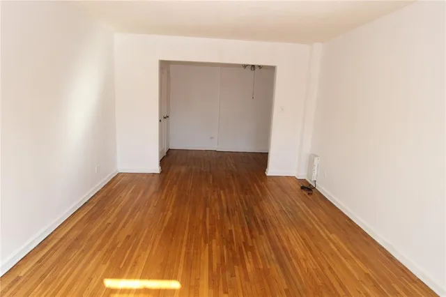a view of a room with wooden floor and bench