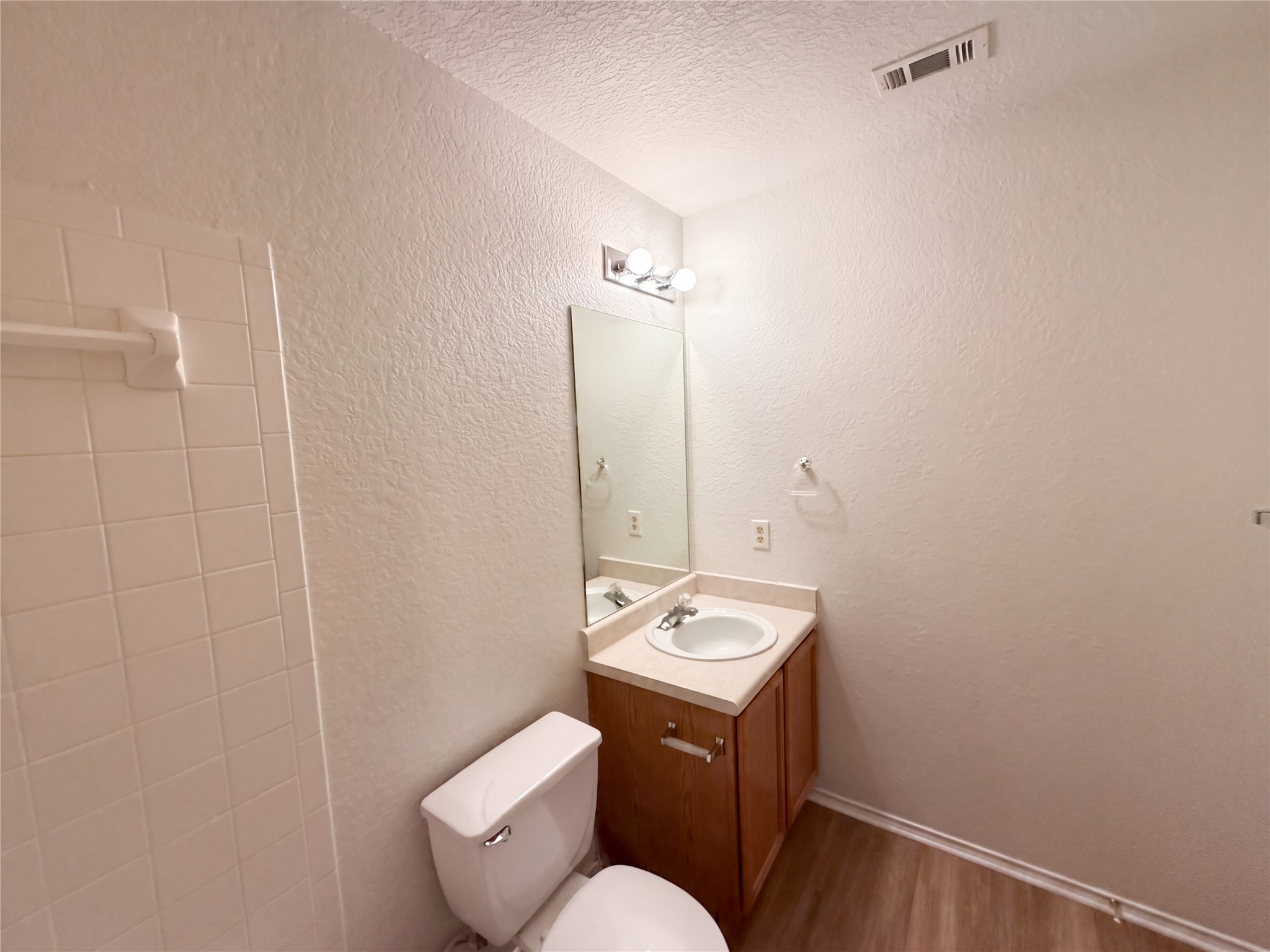 172 Prairie Springs Loop Georgetown, TX 78626 - Photo 15 of 32 Tiled wall surfaces and wood-look flooring define this classic bathroom layout.