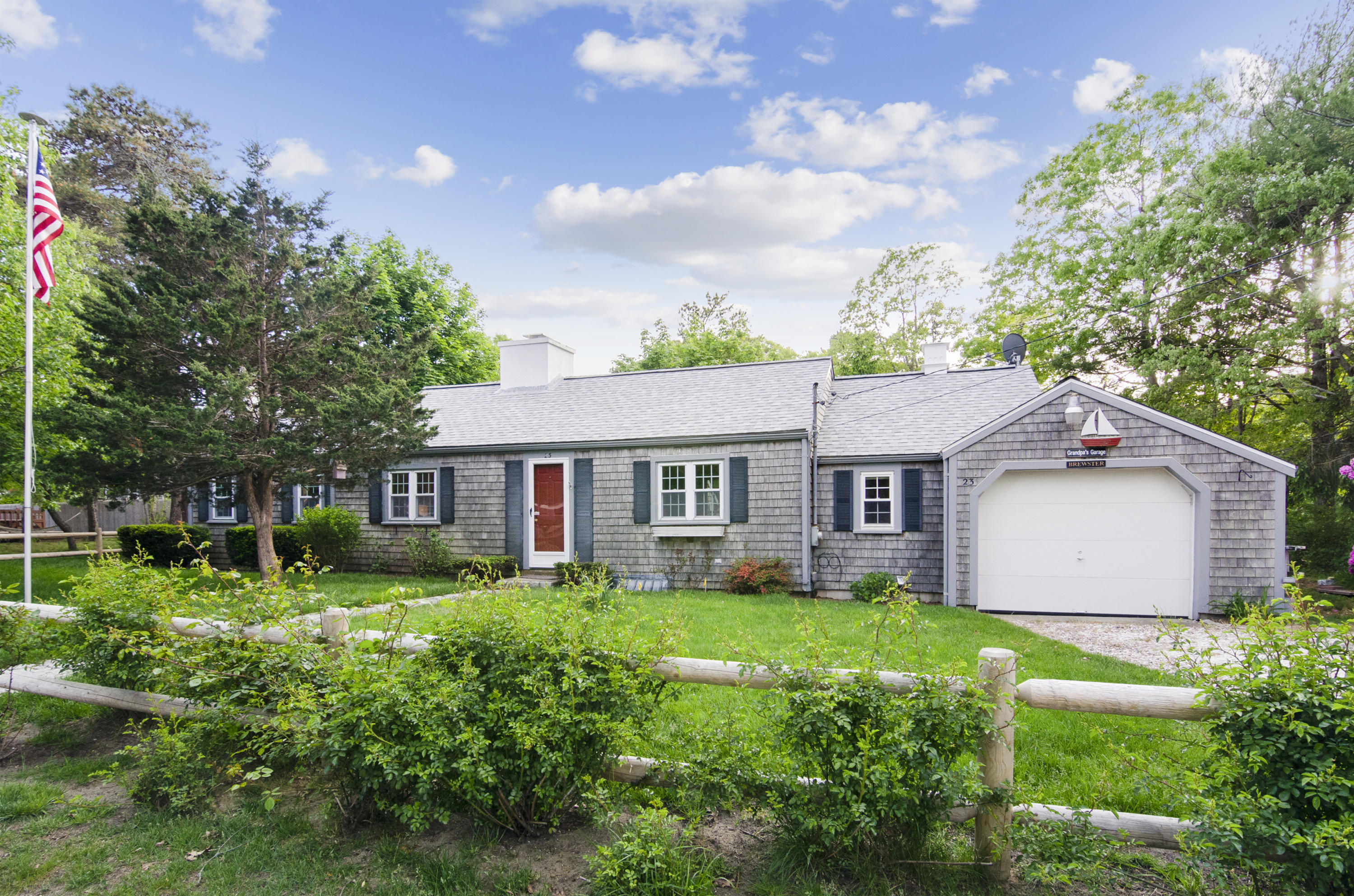 a view of a house with a yard and potted plants