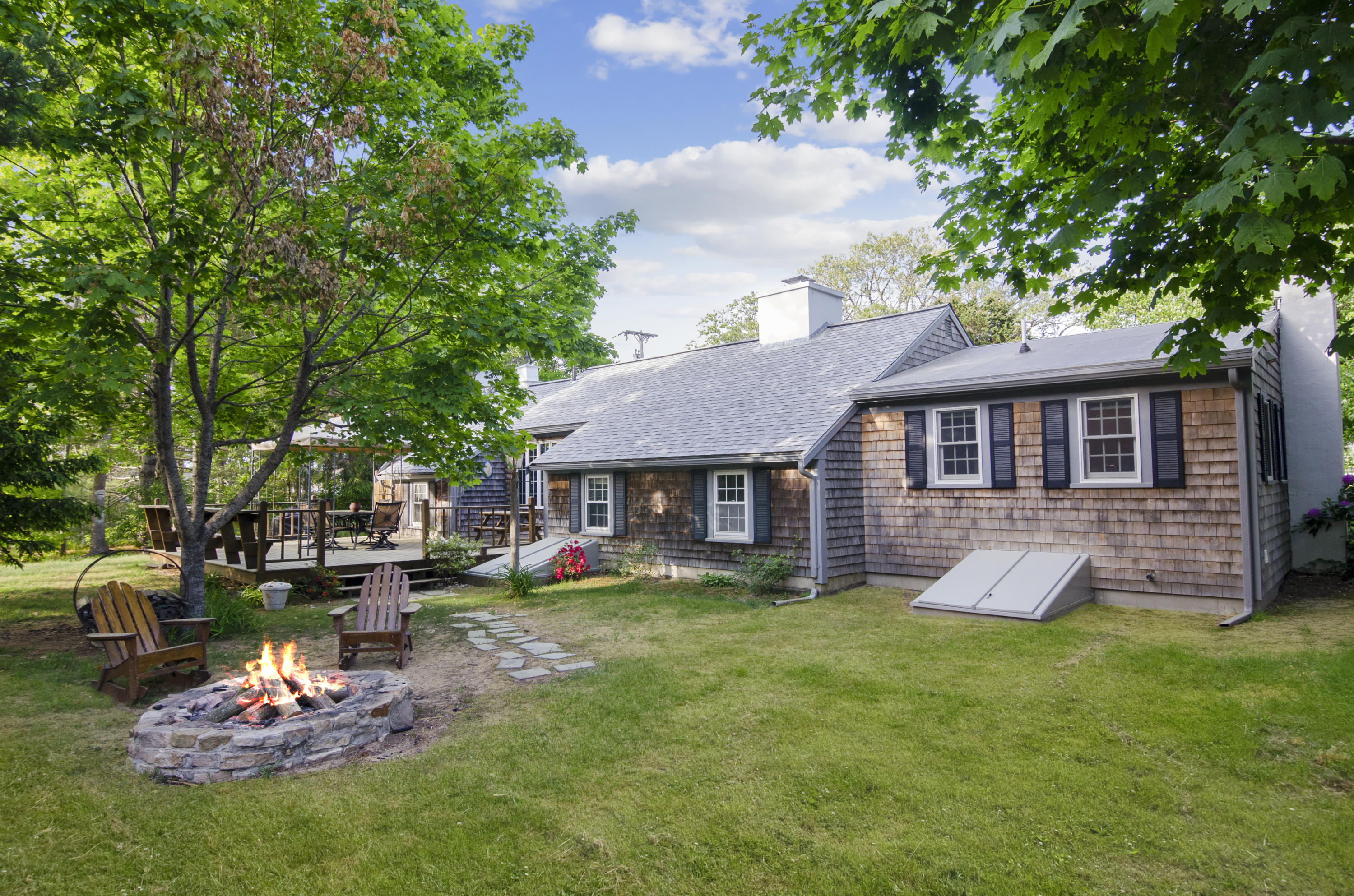 23 Skippers Way Brewster, MA 02631 - Photo 18 of 27 a front view of a house with a yard table and chairs