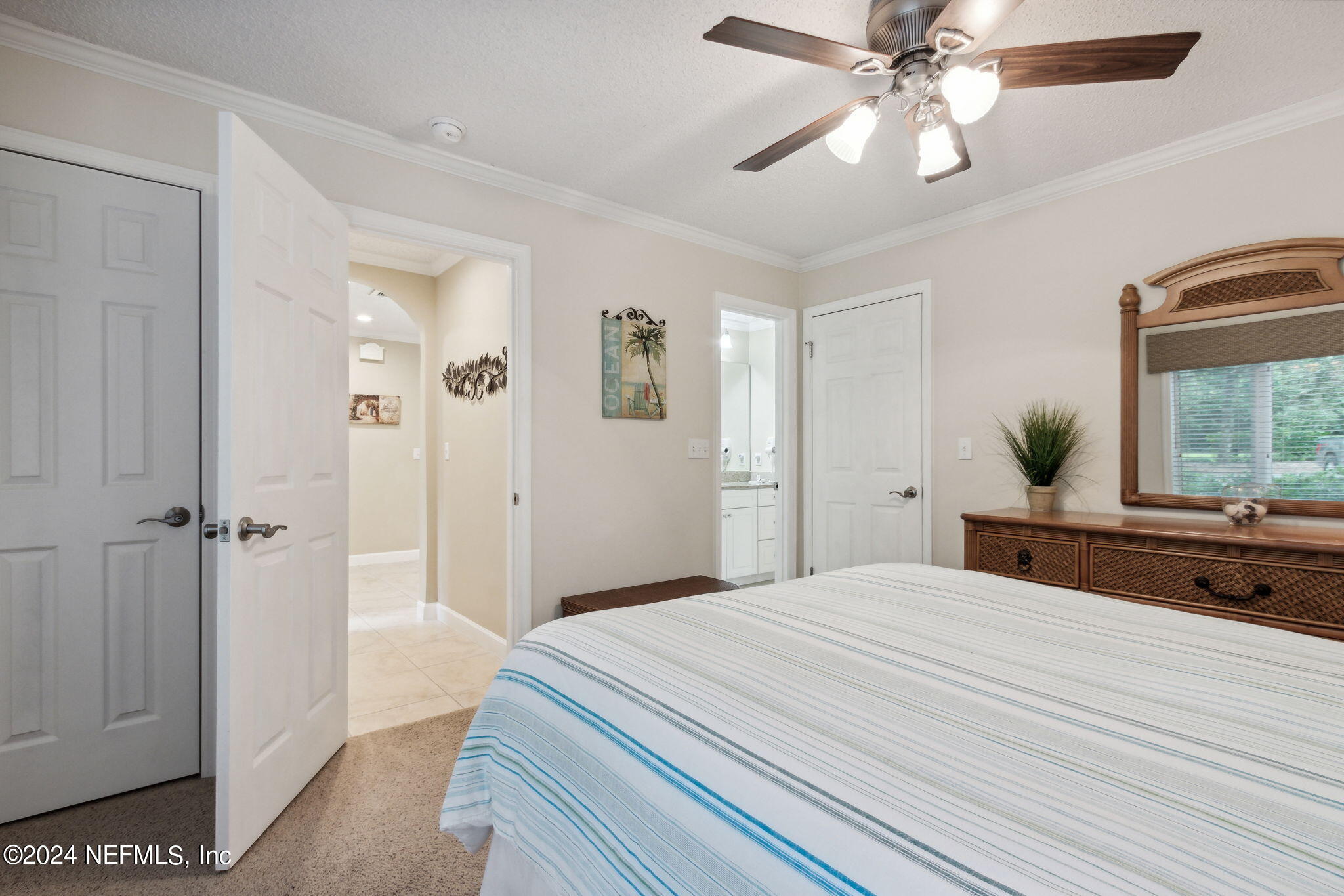 3327 Sea Marsh Road Fernandina Beach, FL 32034 - Photo 22 of 39 a bedroom with a bed and a chandelier