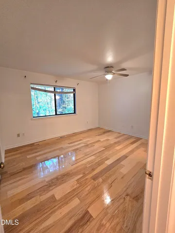 a view of empty room with window and wooden floor