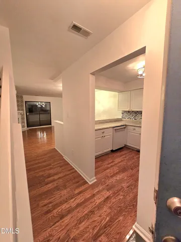 a view of a kitchen with a sink and an empty room