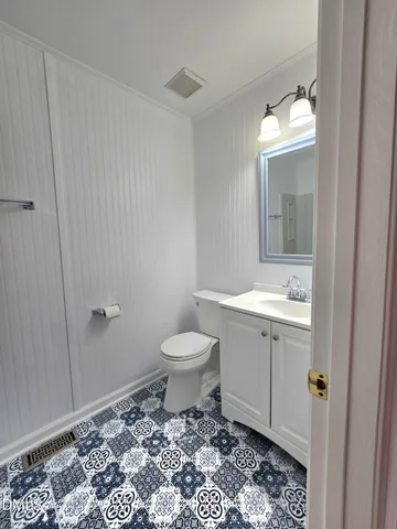 a bathroom with a toilet a sink and mirror