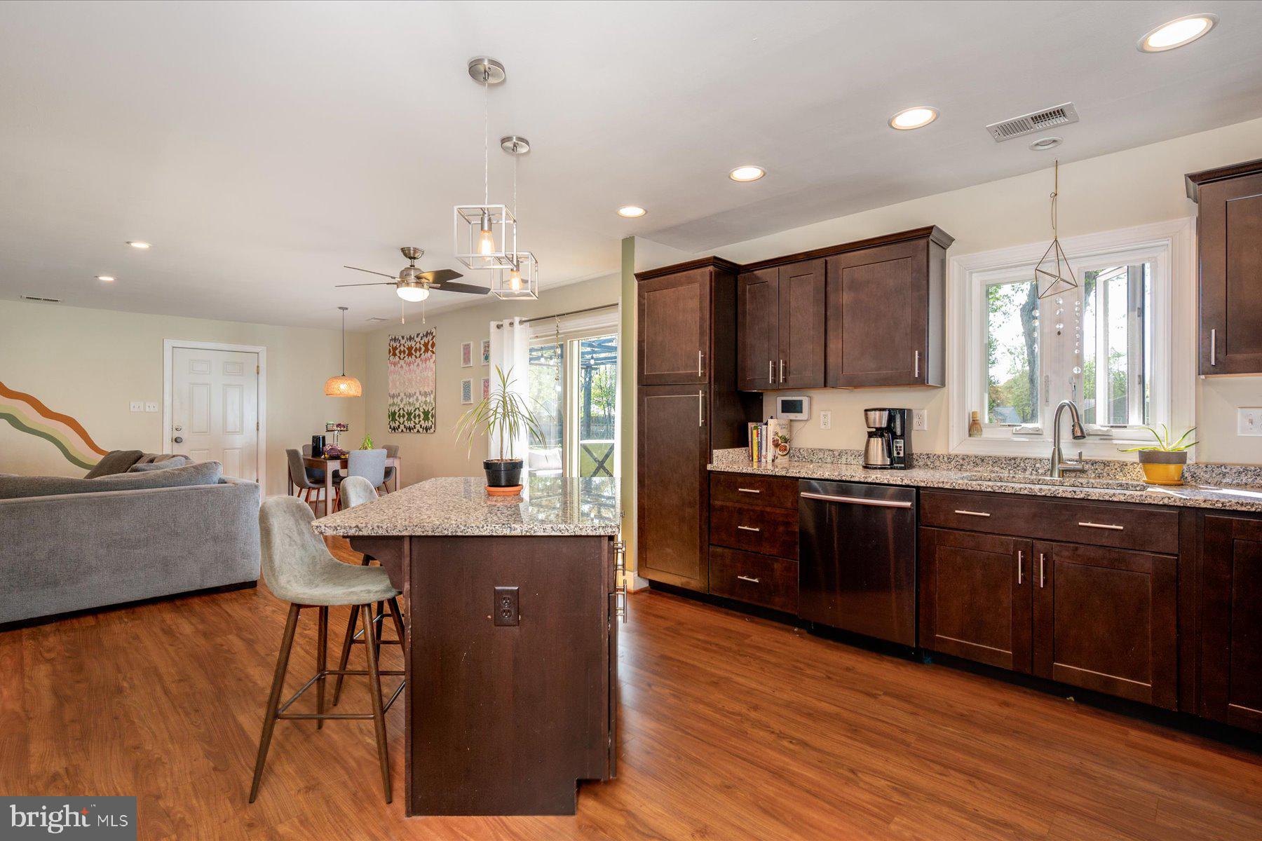 213 Old Magothy Bridge Road Pasadena, MD 21122 - Photo 13 of 31 a large kitchen with kitchen island granite countertop wooden floors and stainless steel appliances