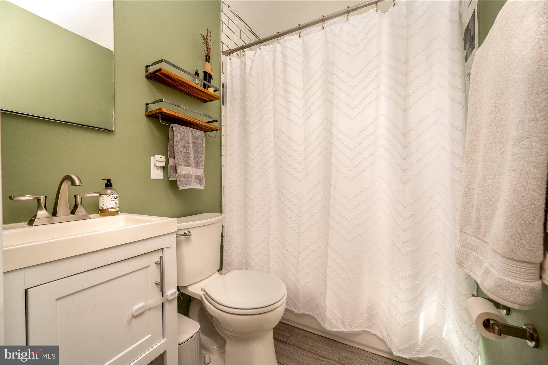 213 Old Magothy Bridge Road Pasadena, MD 21122 - Photo 17 of 31 a bathroom with a sink a toilet and shower curtain