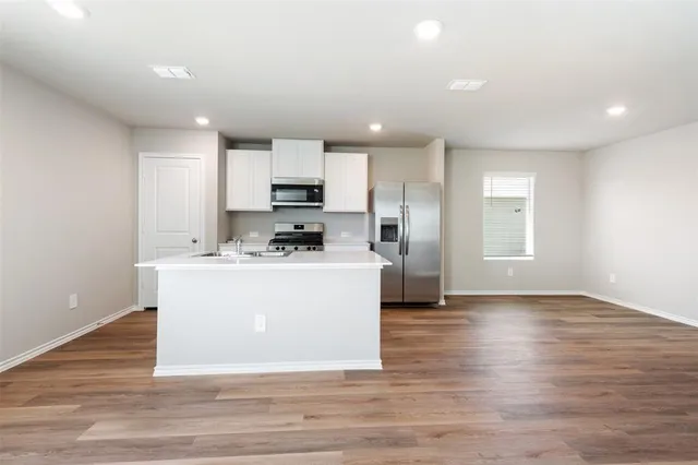 a view of kitchen with stainless steel appliances a refrigerator sink and microwave