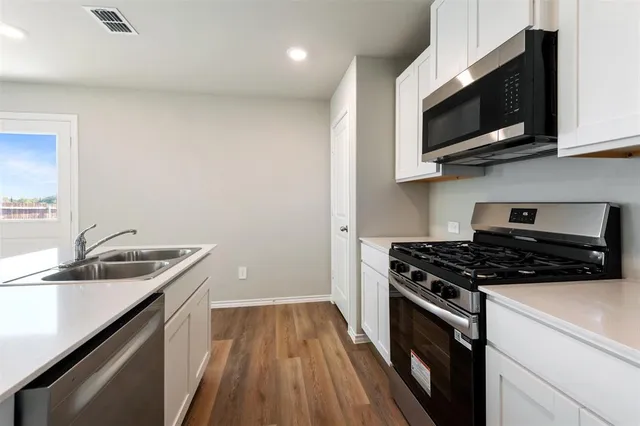 a kitchen with a sink stove and microwave