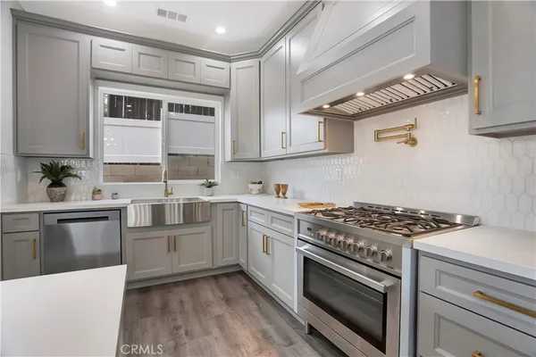 a large white kitchen with lots of counter space dining table and chairs