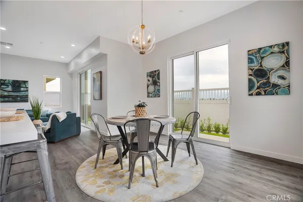 a kitchen with stainless steel appliances kitchen island granite countertop a stove a sink a dining table and chairs
