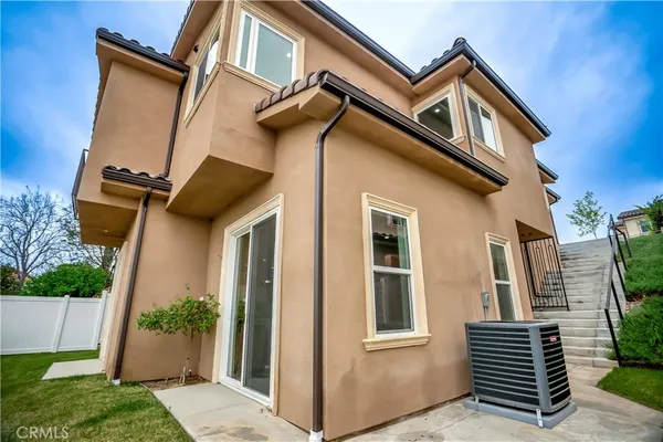 a view of a white house with a small yard and large windows