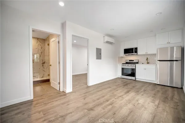 a kitchen with a refrigerator stove and white cabinets
