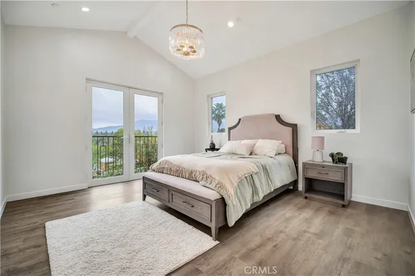 a bedroom with a bed and a chandelier