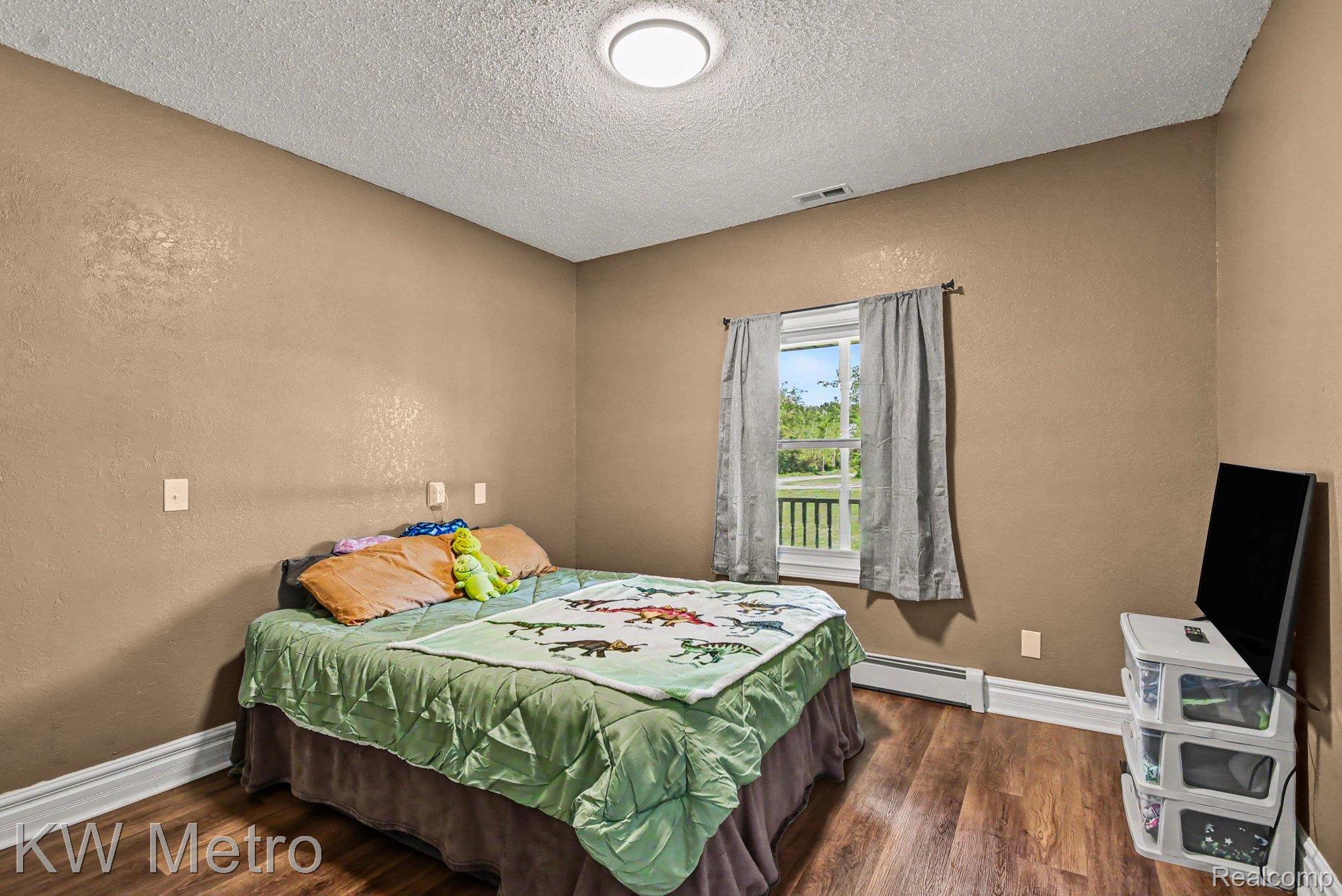 2682 East Haskell Lake Road Harrison, MI 48625 - Photo 26 of 61 Comfortable room featuring wood-finish flooring, a double window with exterior railing visible, white baseboards, and a flush-mount ceiling light