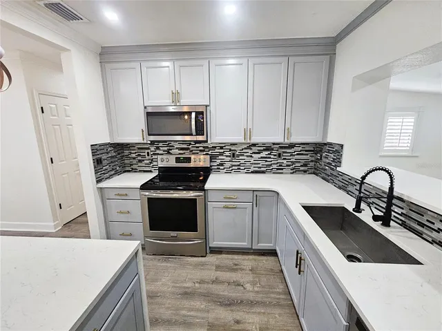 a kitchen with white cabinets sink and stainless steel appliances