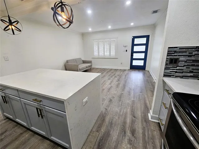 a kitchen with a wooden floor and a stove top oven