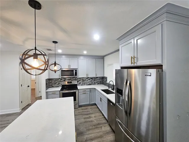 a kitchen with stainless steel appliances granite countertop a stove refrigerator sink and dishwasher