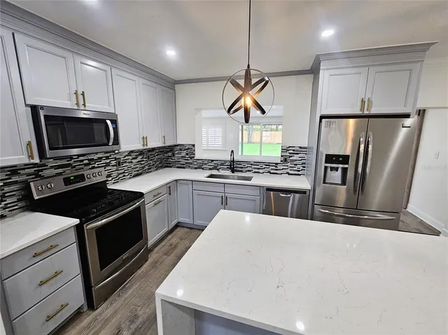 a kitchen with a sink stainless steel appliances and cabinets