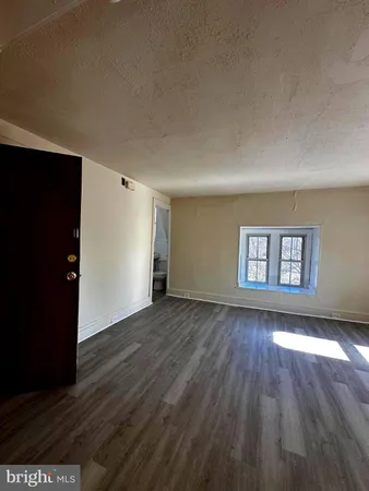 a view of a room with wooden floor and window