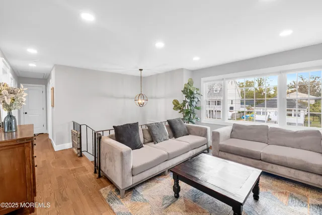 a view of a livingroom with furniture hardwood floor and windows