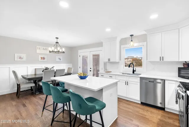 a kitchen with a refrigerator a sink and wooden floor