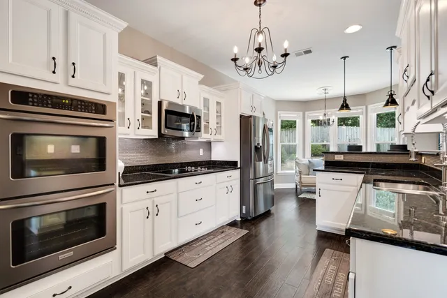 a kitchen with stainless steel appliances granite countertop a stove cabinets and microwave