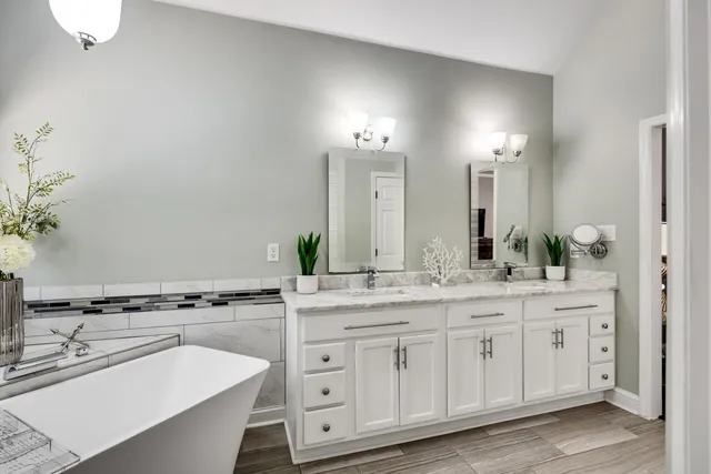 a spacious bathroom with a granite countertop sink and a mirror